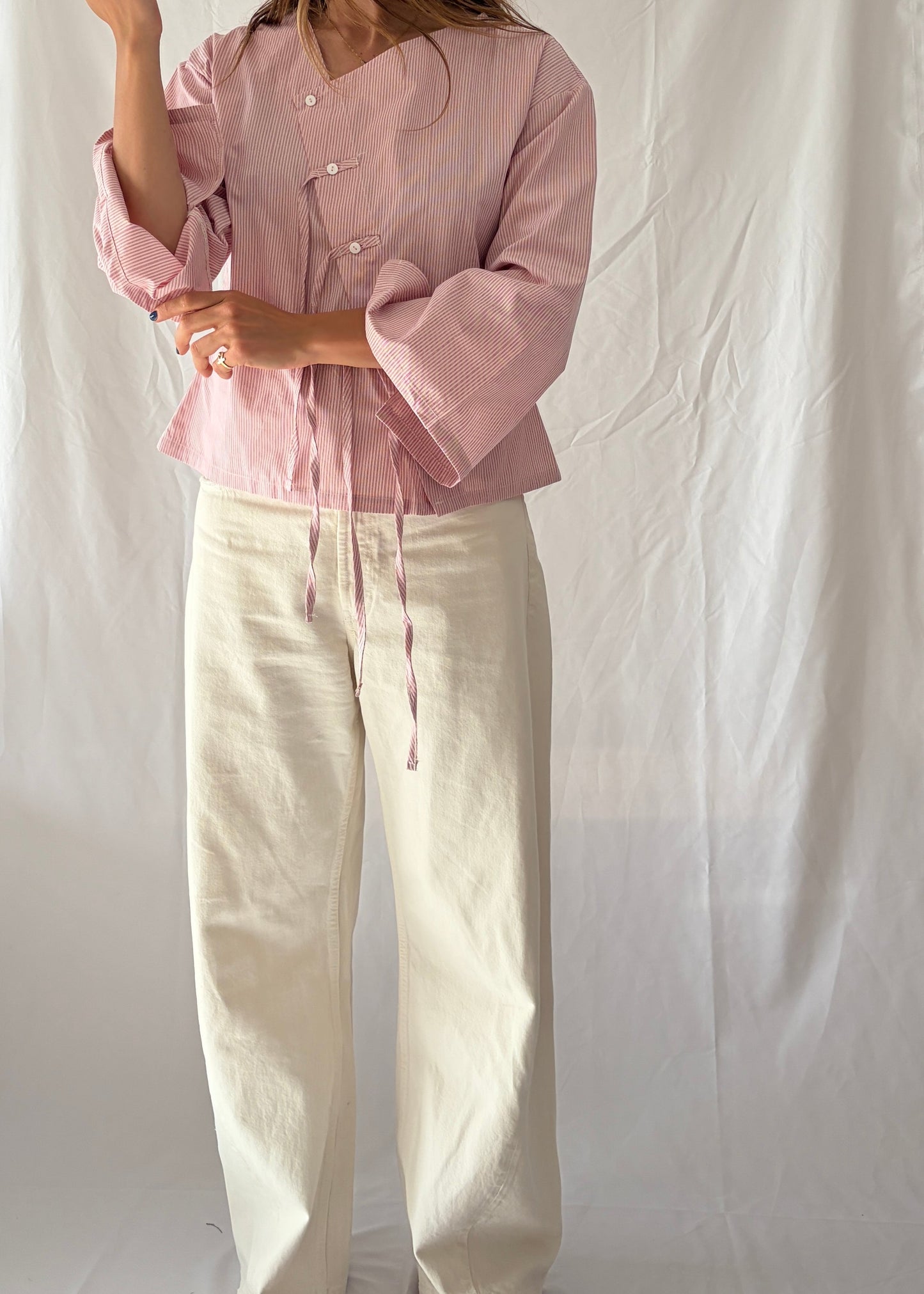 Modelo con blusa asimtrica con flecos Magnolia hecha con algodón orgánicoé