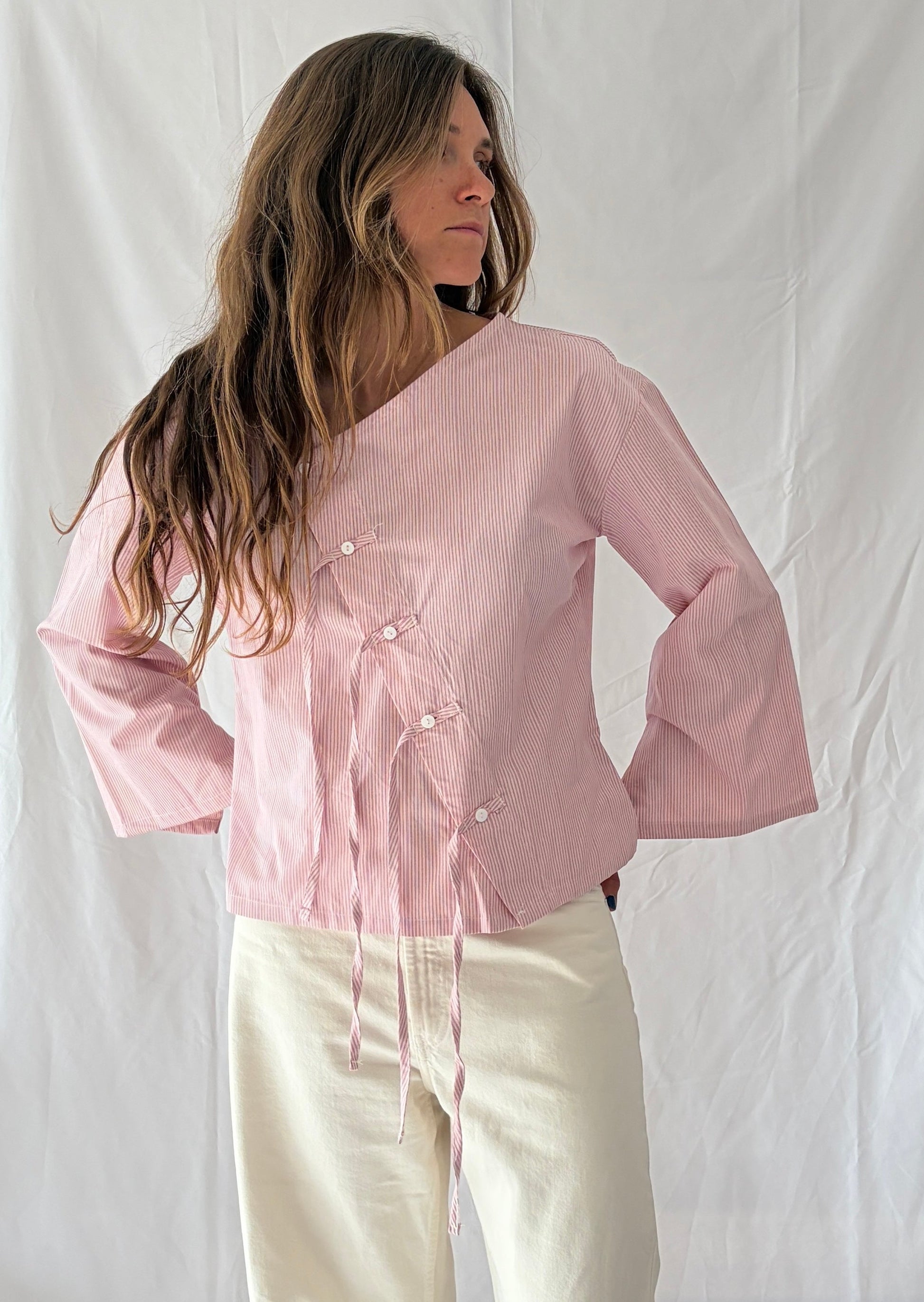 Modelo con blusa asimétrica con flecos Magnolia de algodón orgánico nollen. Color rosa