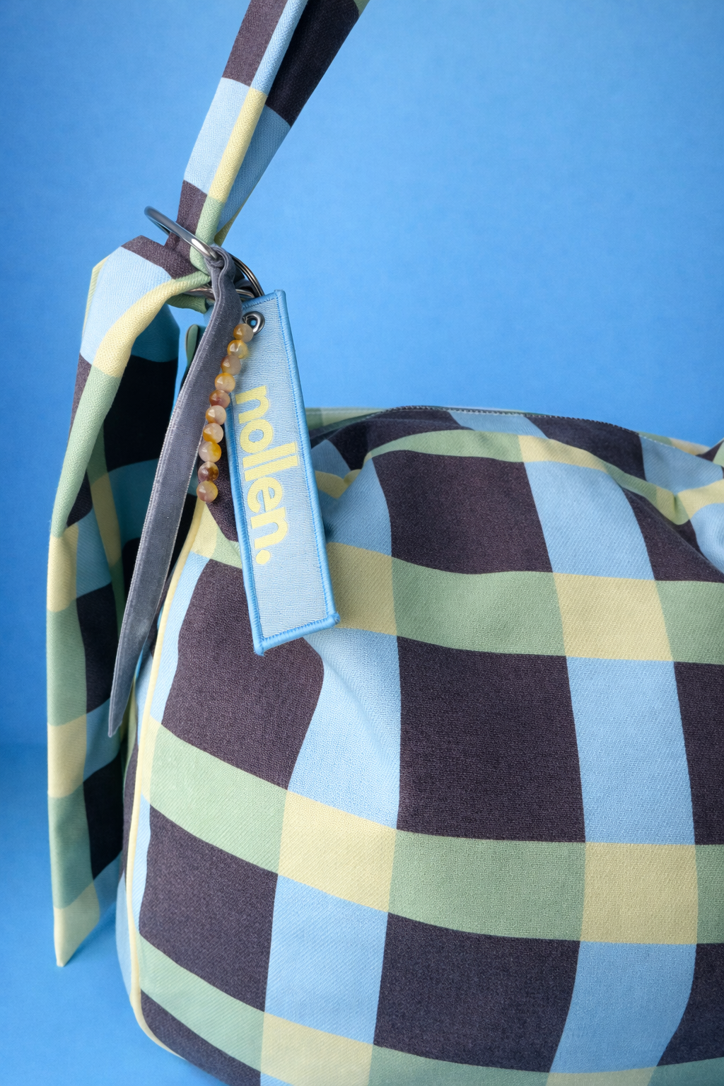 Detalle llavero maxi bolso cuadros color marron azul y amarillo con cremallera