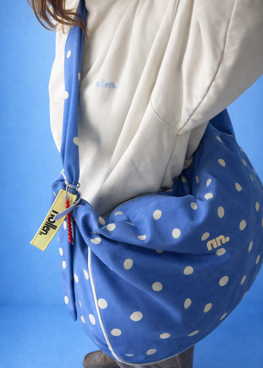Modelo con maxi bolso grande azul lunares topos amarillos